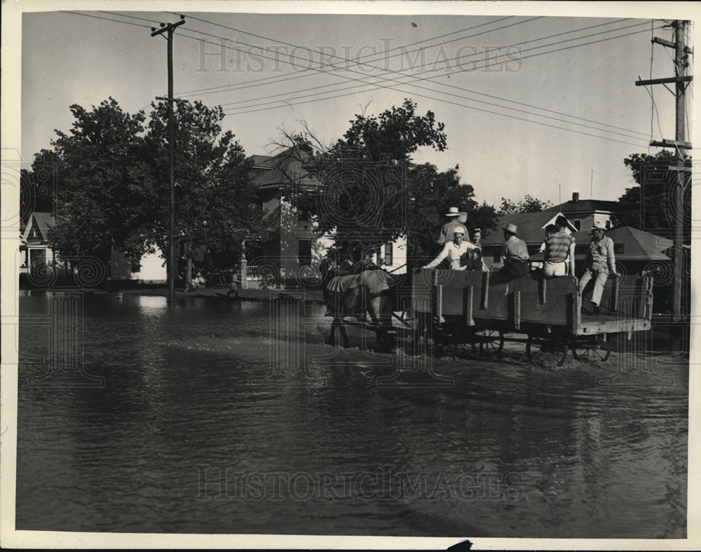 1938 Press Photo men riding in horse drawn wagon thru flooded Kansas town