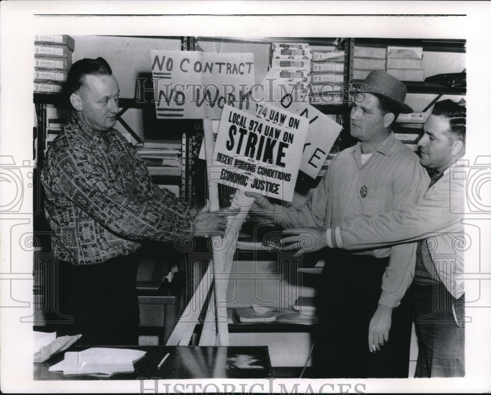 1961 Press Photo Bert Shelby Financial Sec of United Auto Workers passes signs - Historic Images