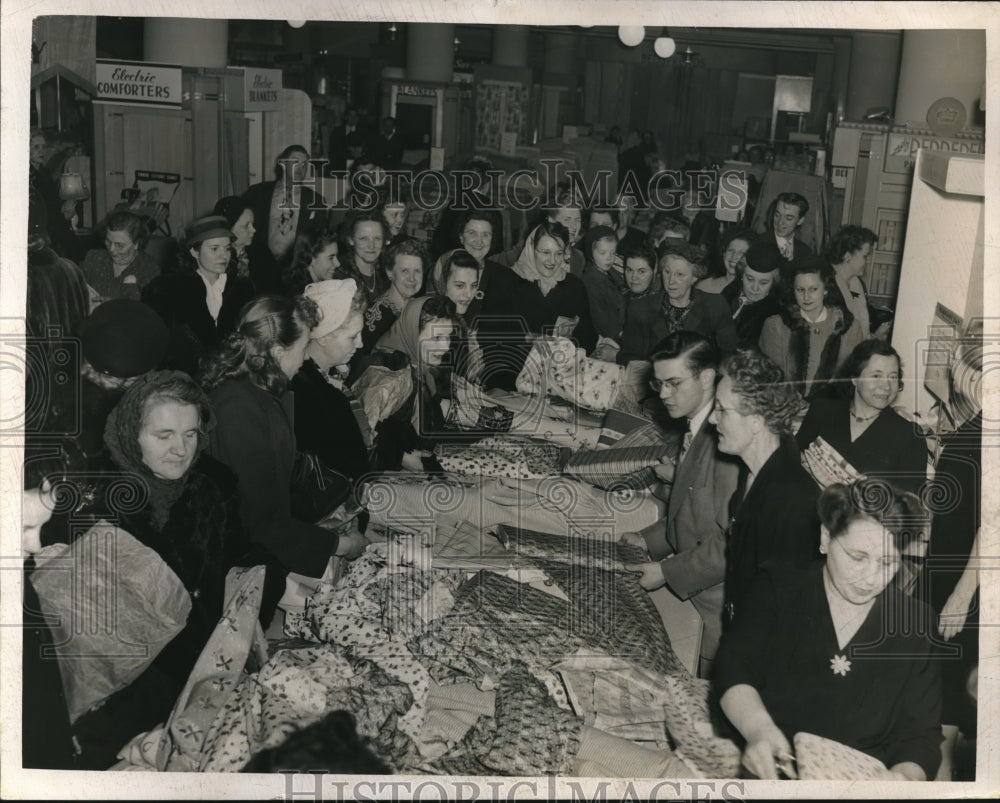 Press Photo Group of Women Looking Over Fabric in Unknown Location