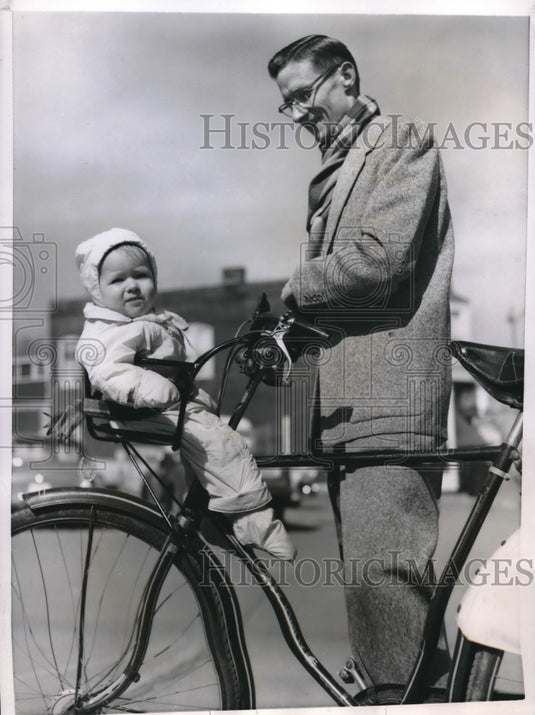 1956 Press Photo Eric Schroll Takes Bundled Up Baby for Ride On Bike Handles- Historic Images