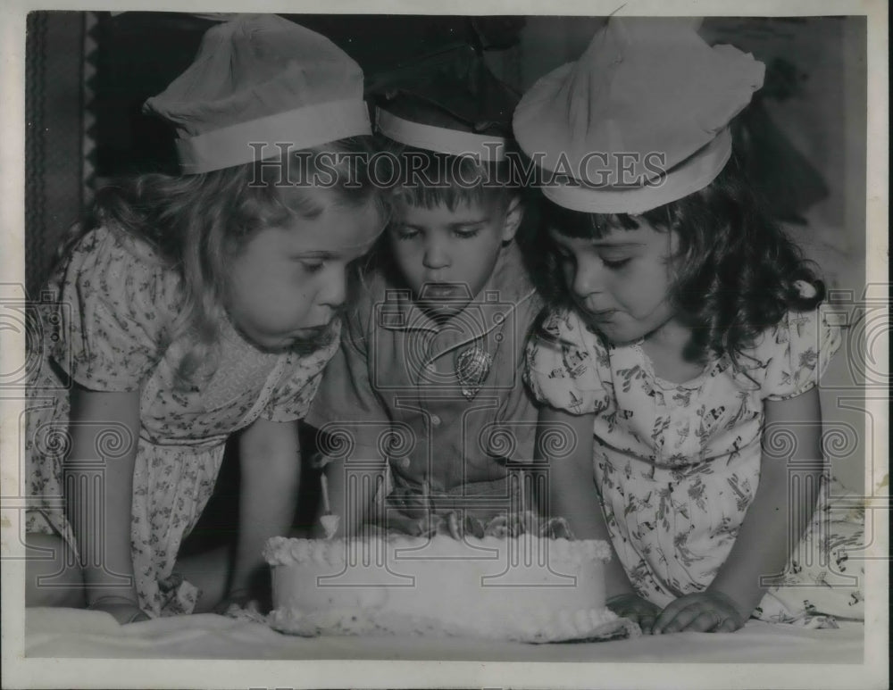 1945 Press Photo Little Girls Blow Out Candles On Birthday Cake
