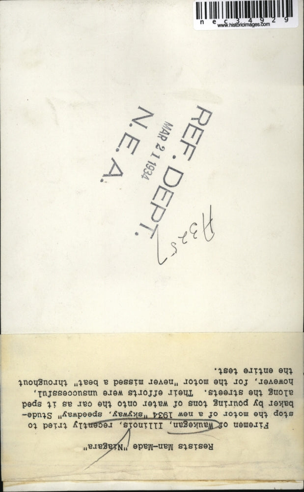 1934 Press Photo Waukegan Firemen try in vain to stop a Studebaker with water