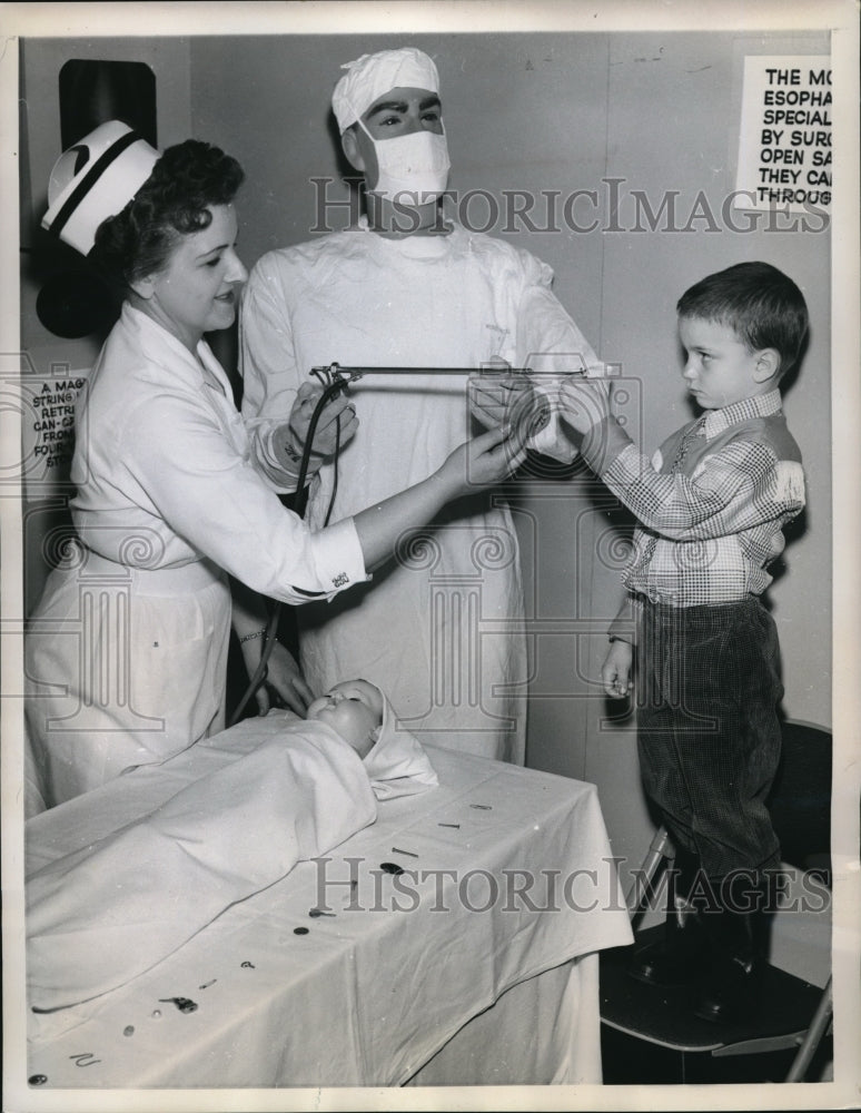 Load image into Gallery viewer, 1960 Press Photo Dr. displays for eps used to remove safety pins from kids tummy
