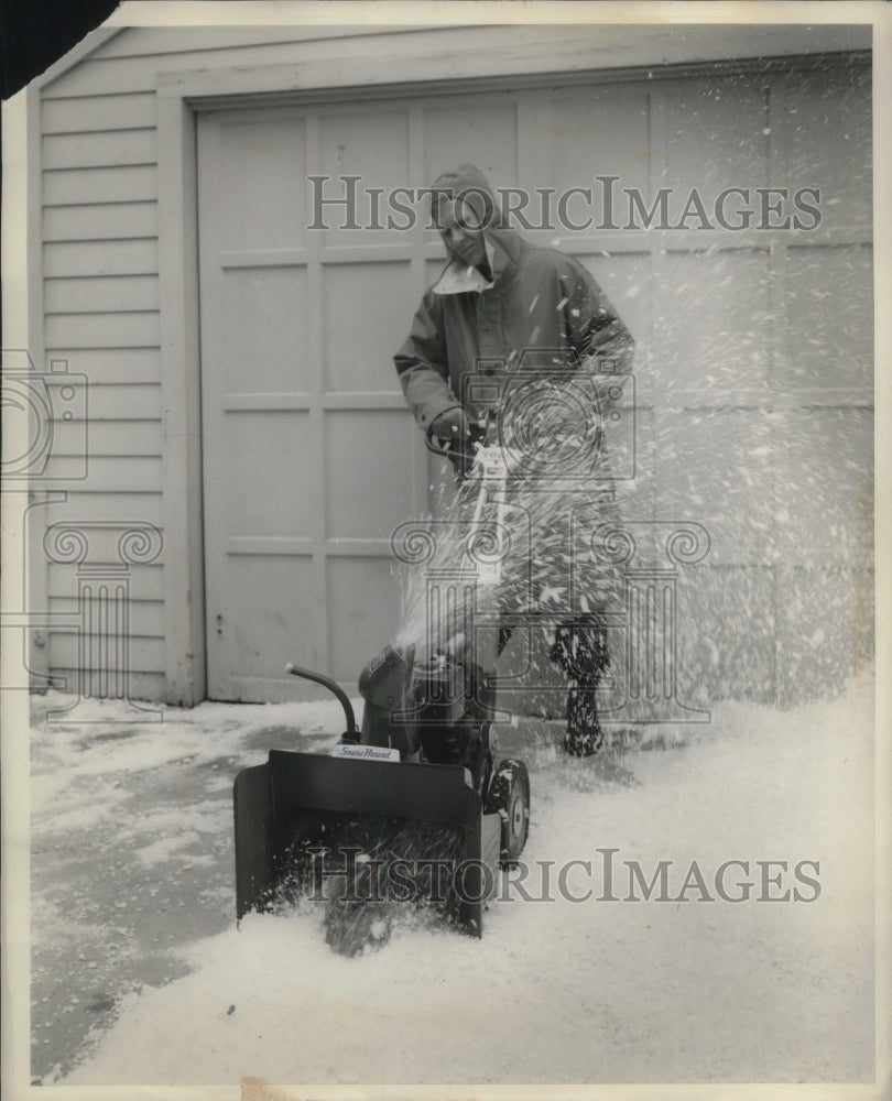 1959 Press Photo Man using snow blower to clear homes driveway