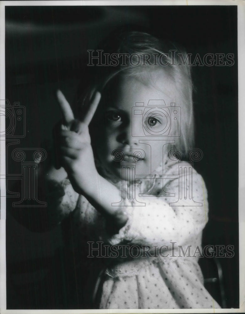 Load image into Gallery viewer, 1970 Press Photo Maeve O'Sullivan, 3, has to battle to make the peace sign
