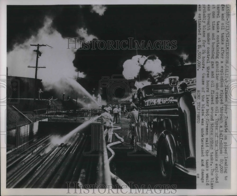 1951 Press Photo Firemen pour foam on gas and oil tanks after an explosion ignited some barrels- Historic Images