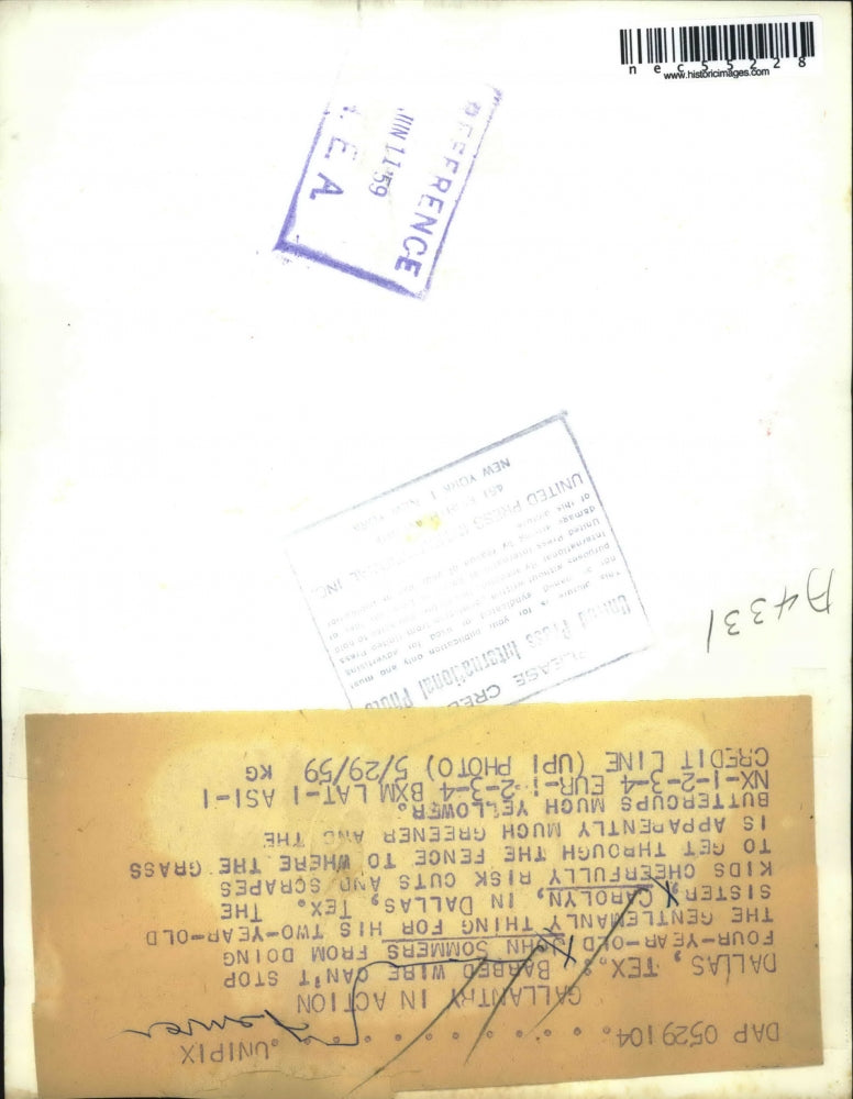 1959 Press John Sommers helps his two year old sister Carolyn over barb wire in