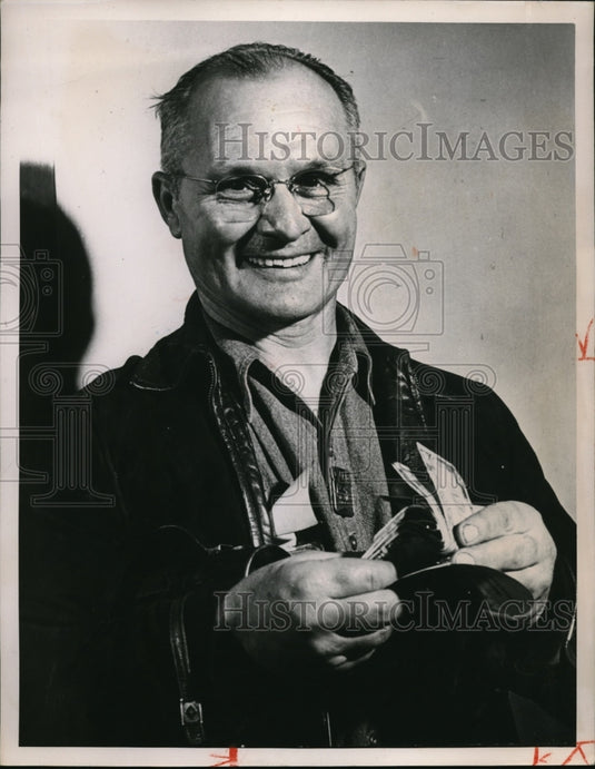 1948 Press Photo An Unidentified man showing off his winnings, all smiles