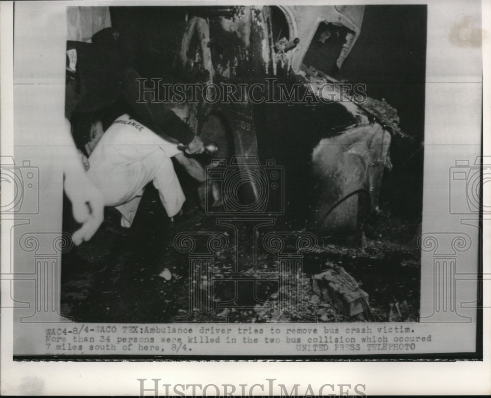1952 Press Photo Ambulance driver tries to remove bus crash victim.