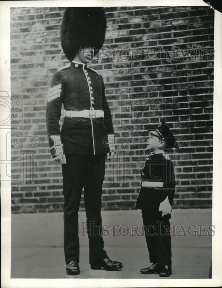 Load image into Gallery viewer, 1935 Press Photo Warley Barracks, Essex, England Guards member &amp; a child
