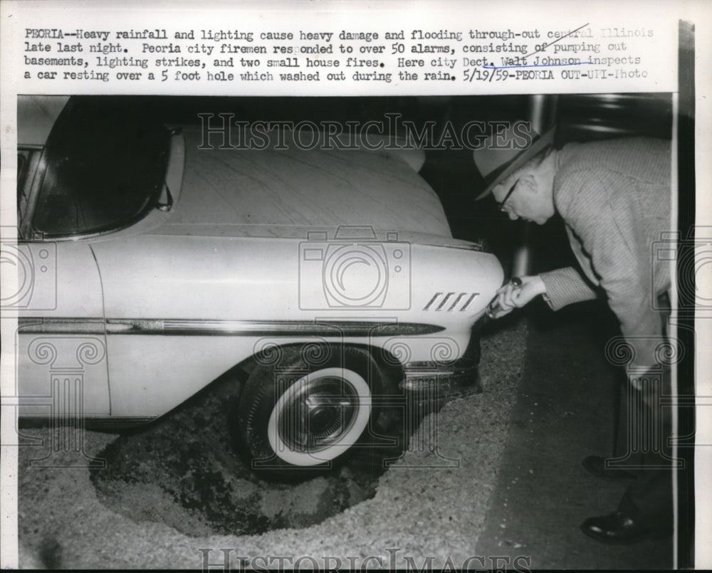 1959 Press Photo Peoria Illinois Cop Walt Johnson Looks At Car Stuck In Pothole