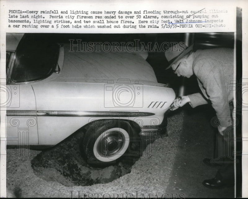 Load image into Gallery viewer, 1959 Press Photo Peoria Illinois Cop Walt Johnson Looks At Car Stuck In Pothole
