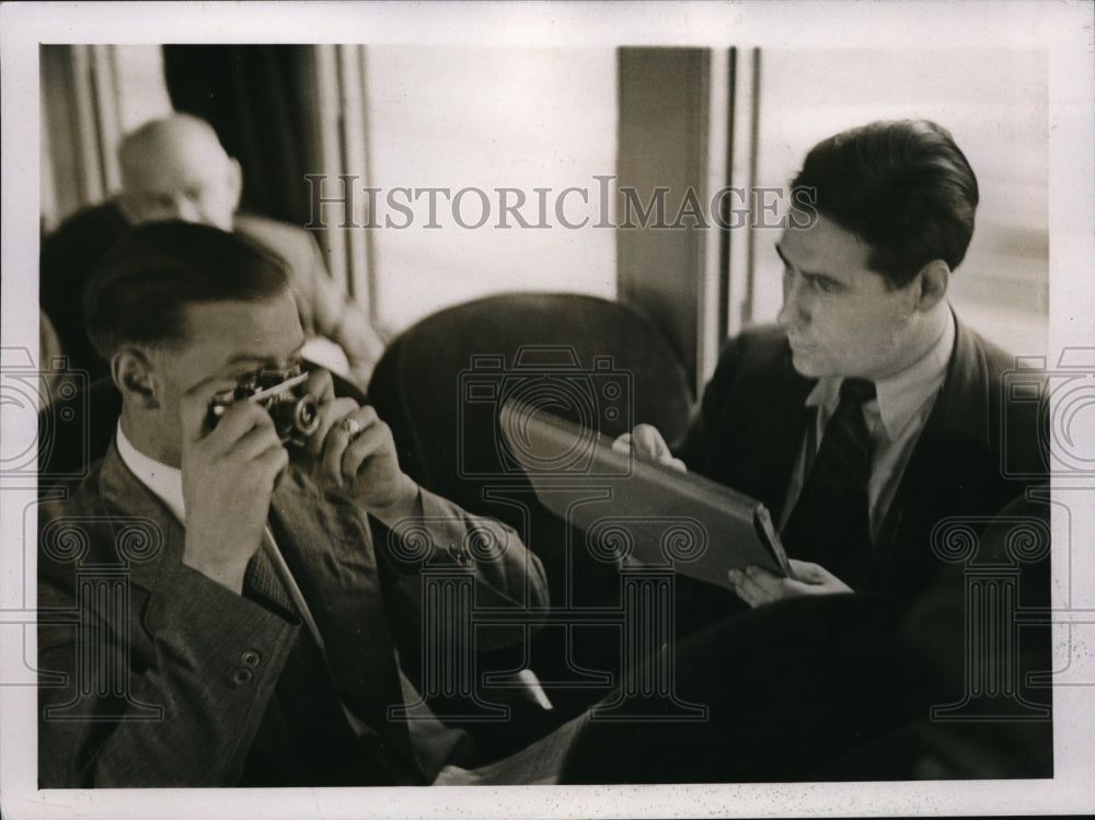1937 Press Photo While one man photographs, the other paints as train moves.