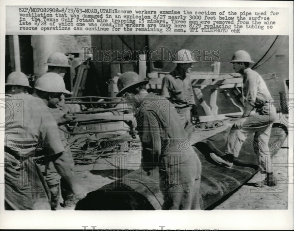 1963 Press Photo Rescue Workers examine pipe used for ventilation that was damaged in explosion at T