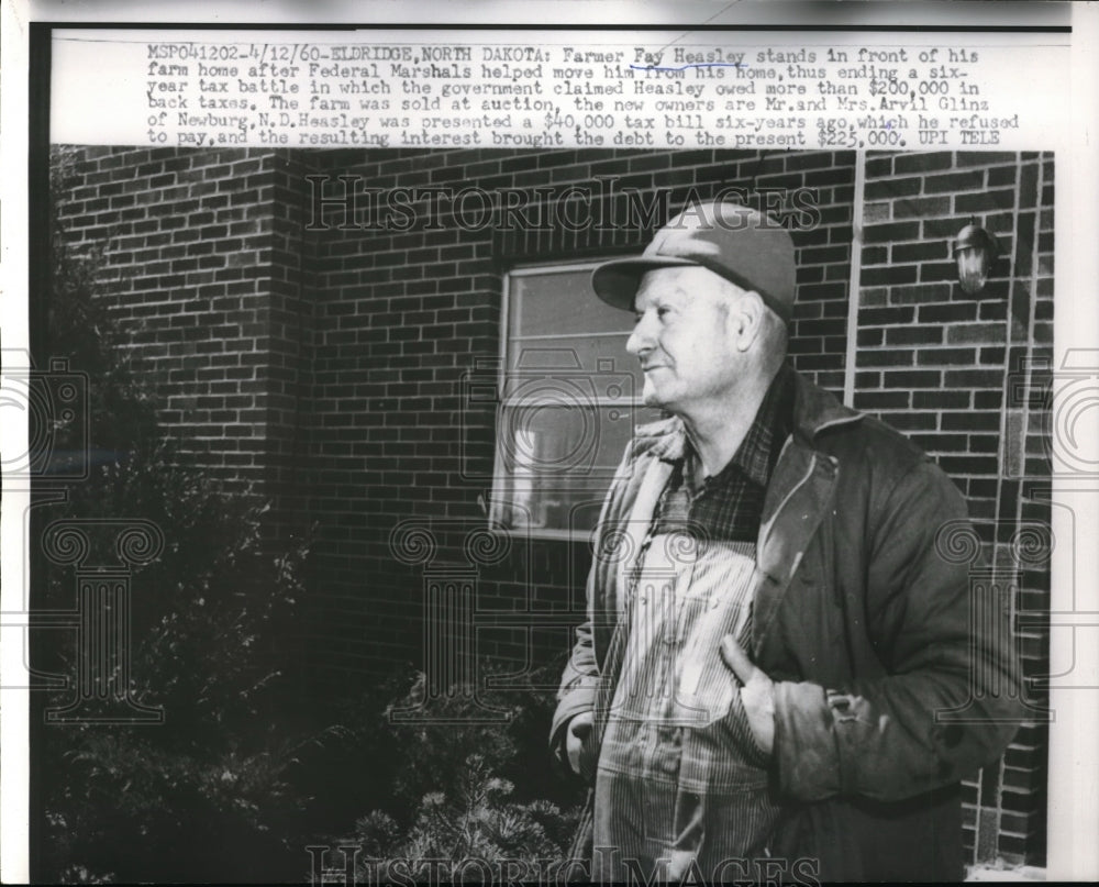 1960 Press Photo Framer Fay Heasley stands in front of his farm as Federal Marshals move him from hi