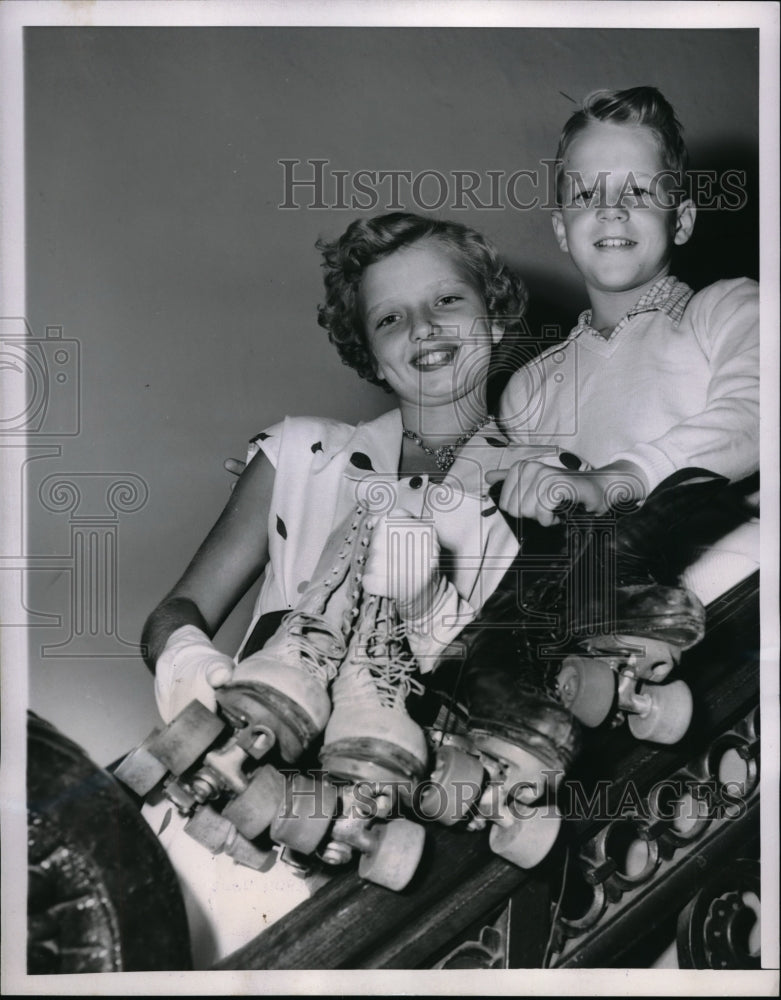 Load image into Gallery viewer, 1953 Press Photo Karen Hoster and Michael Reid holding their roller skates
