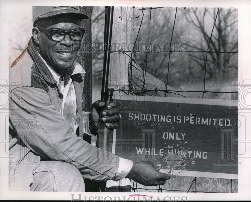 Press Photo Joe Griffin while holding a sign