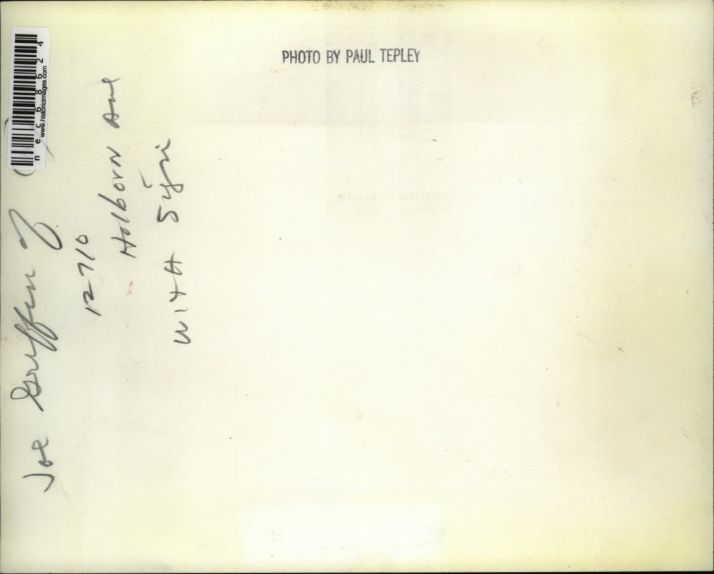 Press Photo Joe Griffin while holding a sign