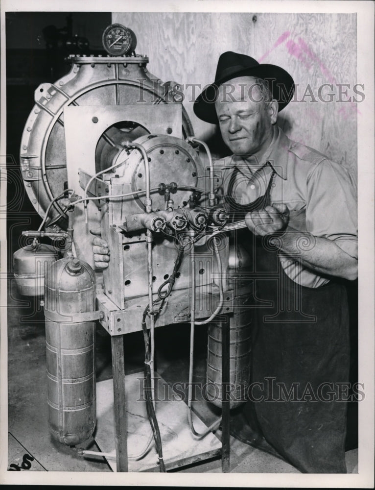 1949 Press Photo Soiled Worker Turns Wrench On Hydraulic Machine - nec69455