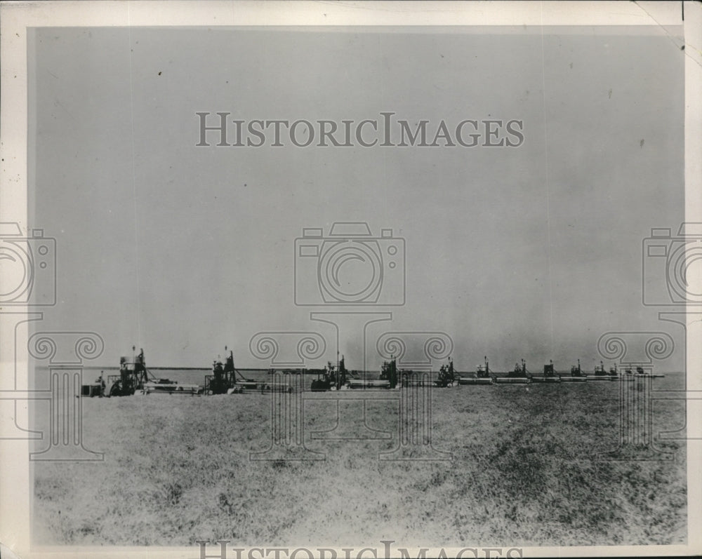 1940 Press Photo A wheat field as harvesters pass through it