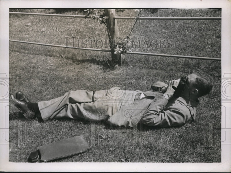 Load image into Gallery viewer, 1937 Press Photo Man lays in the grass to take a photograph - nec71382
