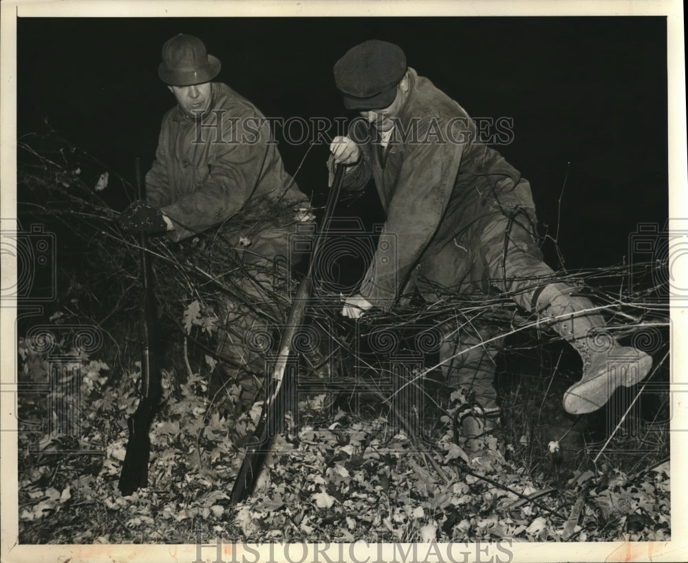 1939 Press Photo Men with rifles try to step over afence