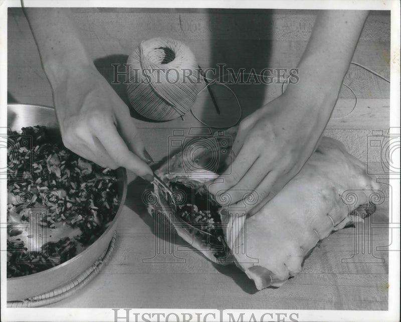 Load image into Gallery viewer, 1958 Press Photo A woman prepares a lamb shoulder for cooking
