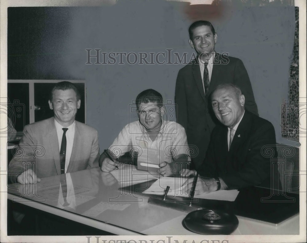 Press Photo Four business men arounf=d a table sign contracts