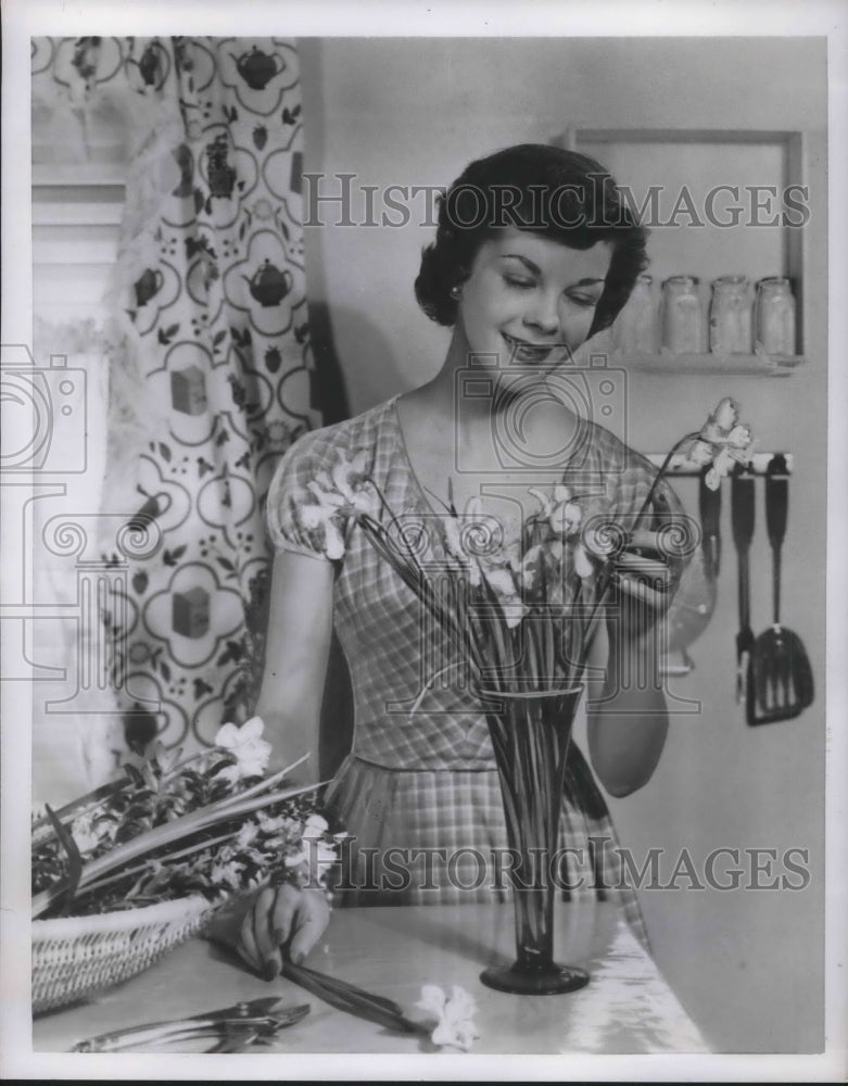 1951 Press Photo W woman arranges cut flowes in vase at her home