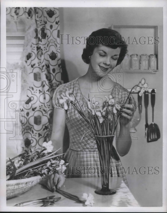1951 Press Photo W woman arranges cut flowes in vase at her home