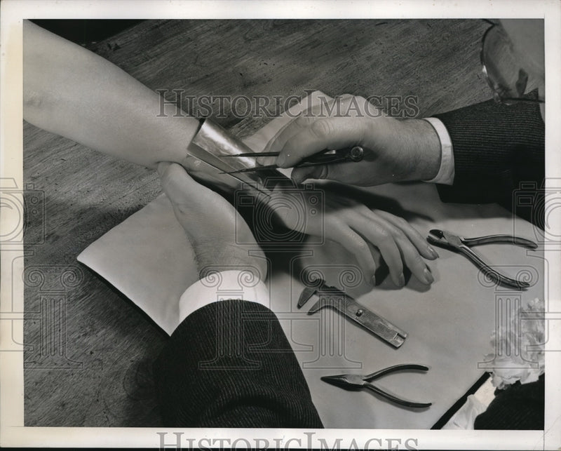 Load image into Gallery viewer, 1939 Press Photo LAdy has a plaster cast made of her wrist with tin bracelet
