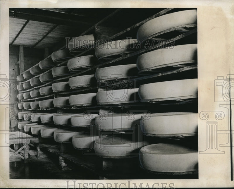 Load image into Gallery viewer, 1941 Press Photo Wheels of cheese on shelves in Switzerland
