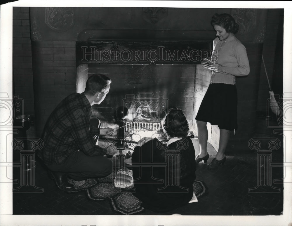 1942 Press Photo A group of people tost weinies at a fireplace in the country