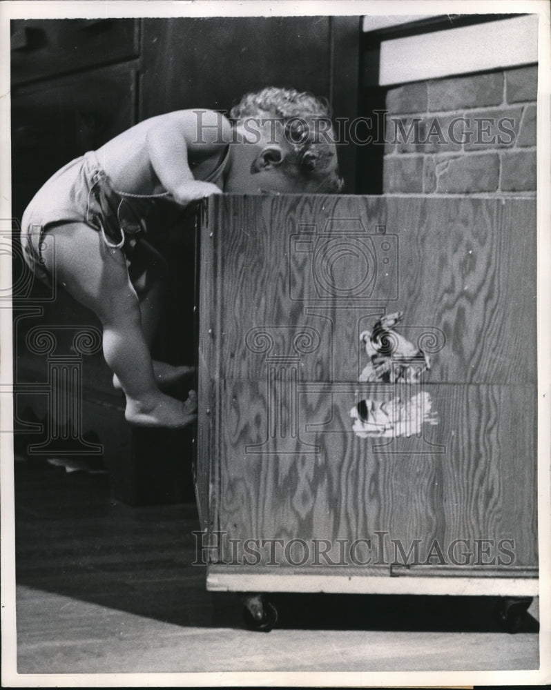 1957 Press Photo Baby Keith climbs the side of his toy chest- Historic Images