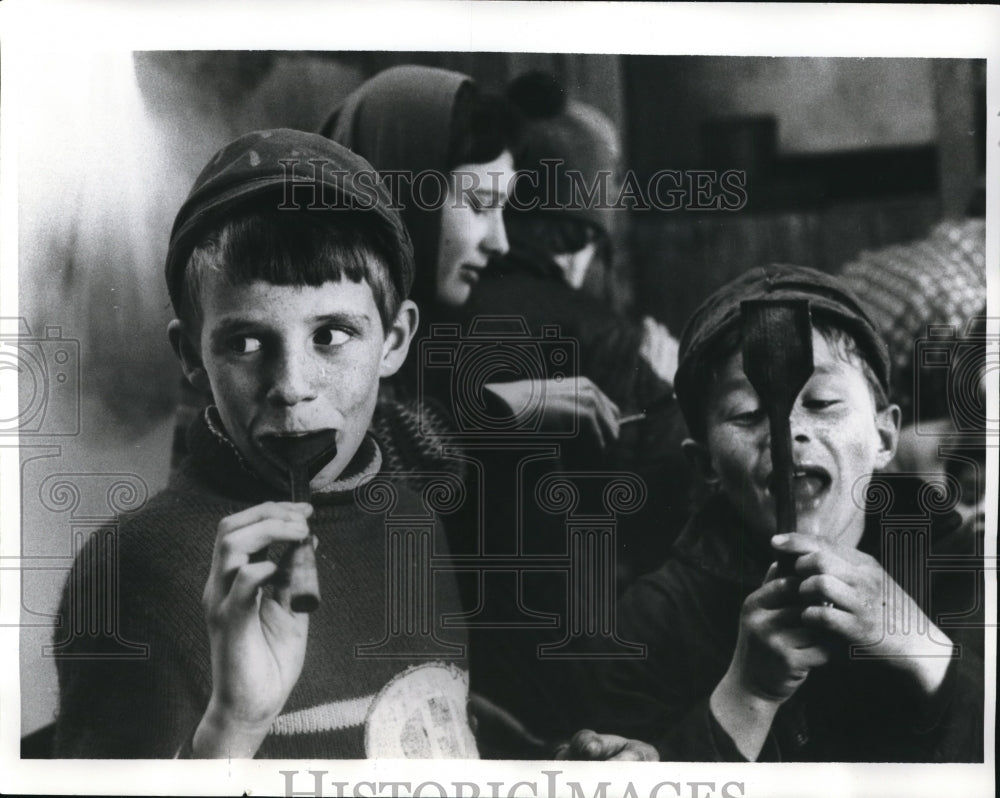 1969 Press Photo Little boys taste maple syrup from paddles at harvest time