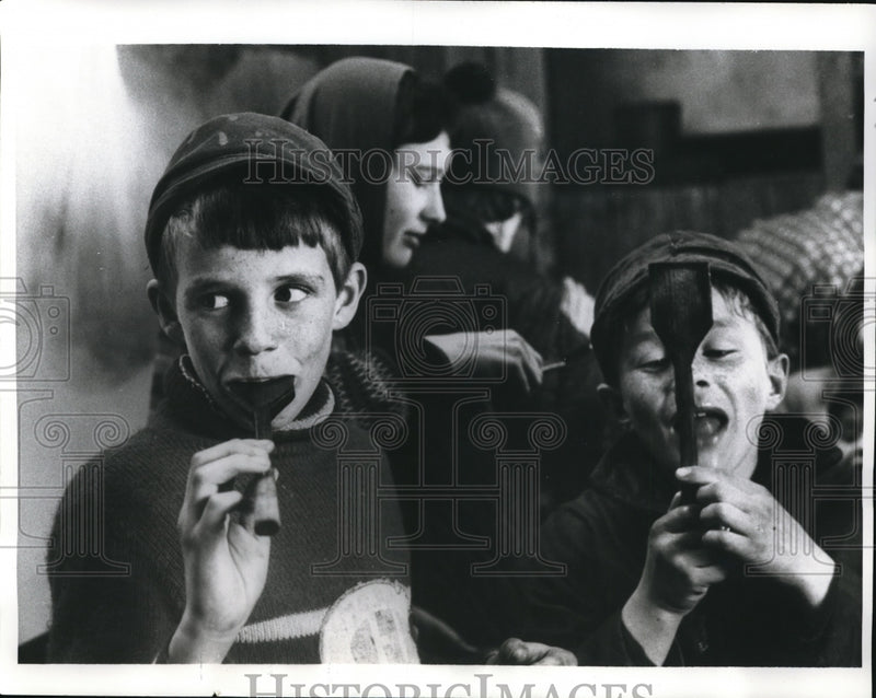 Load image into Gallery viewer, 1969 Press Photo Little boys taste maple syrup from paddles at harvest time
