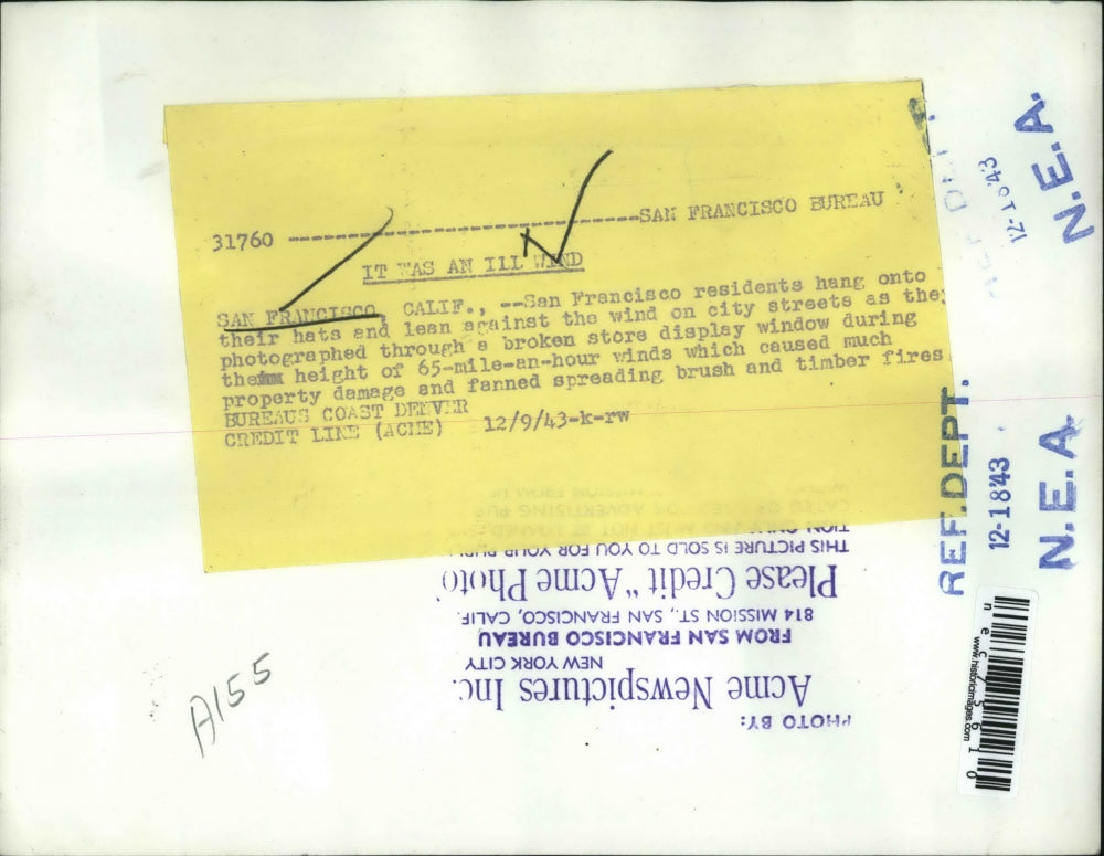 1943 Press PhotoResidents hang onto their hats as winds blow