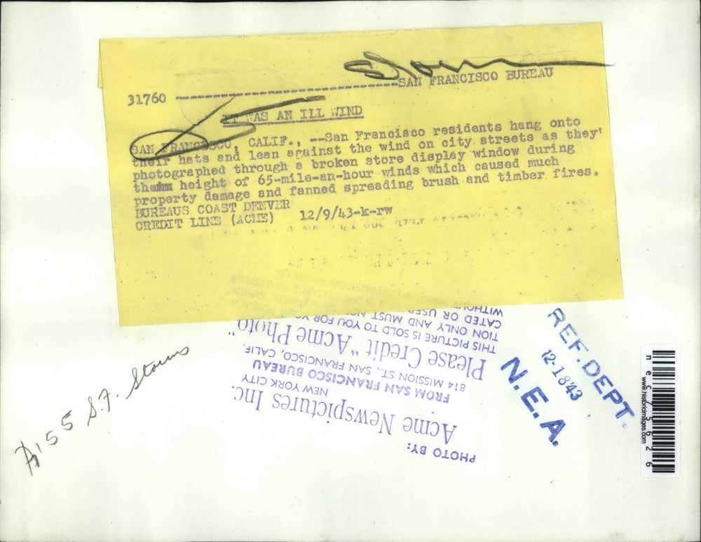 1943 Press Photo Residents hold onto their hats and lean against fierce winds