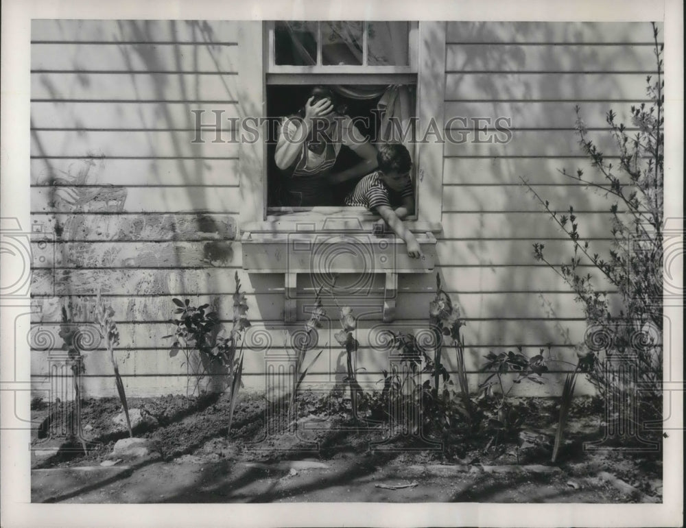 1941 Press Photo Young David McLane Shows Mom Gladiolis on the Side of the House