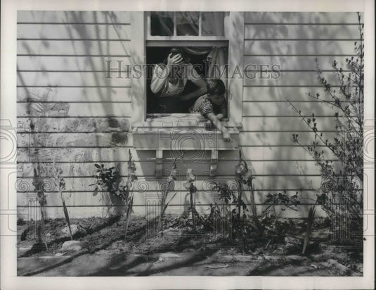 1941 Press Photo Young David McLane Shows Mom Gladiolis on the Side of the House