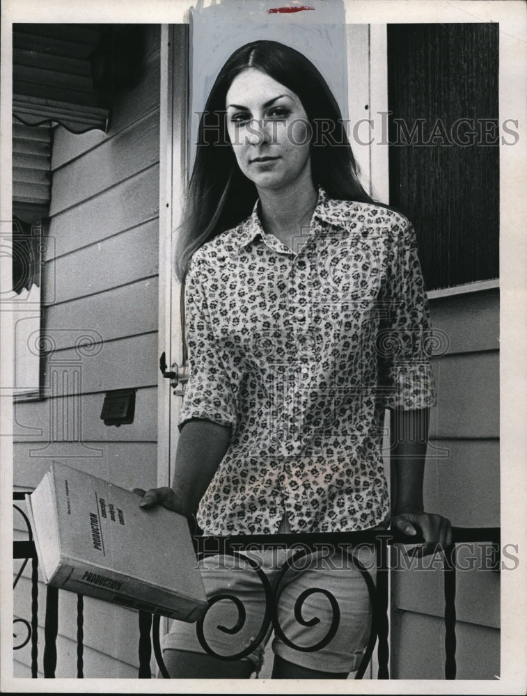 Press Photo Student with "Production" book in hand