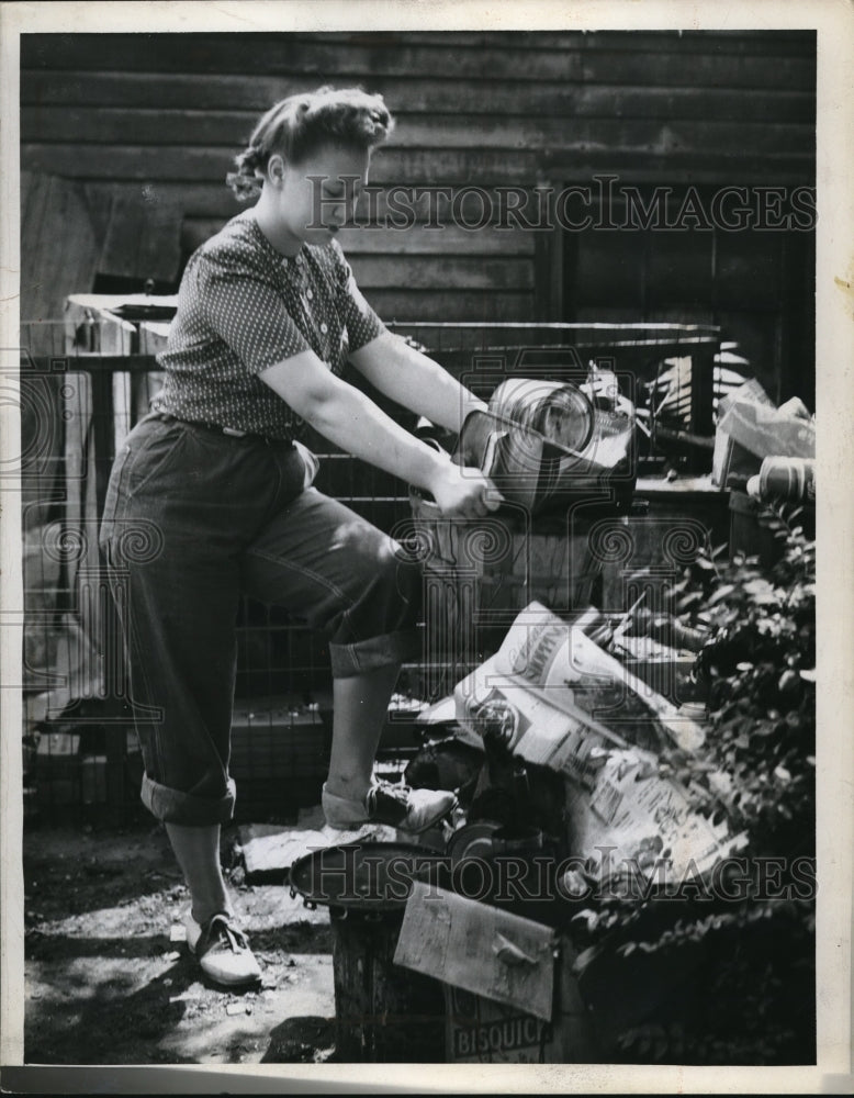 1946 Press Photo Marge Armstrong ealing with trash pile getting out of control