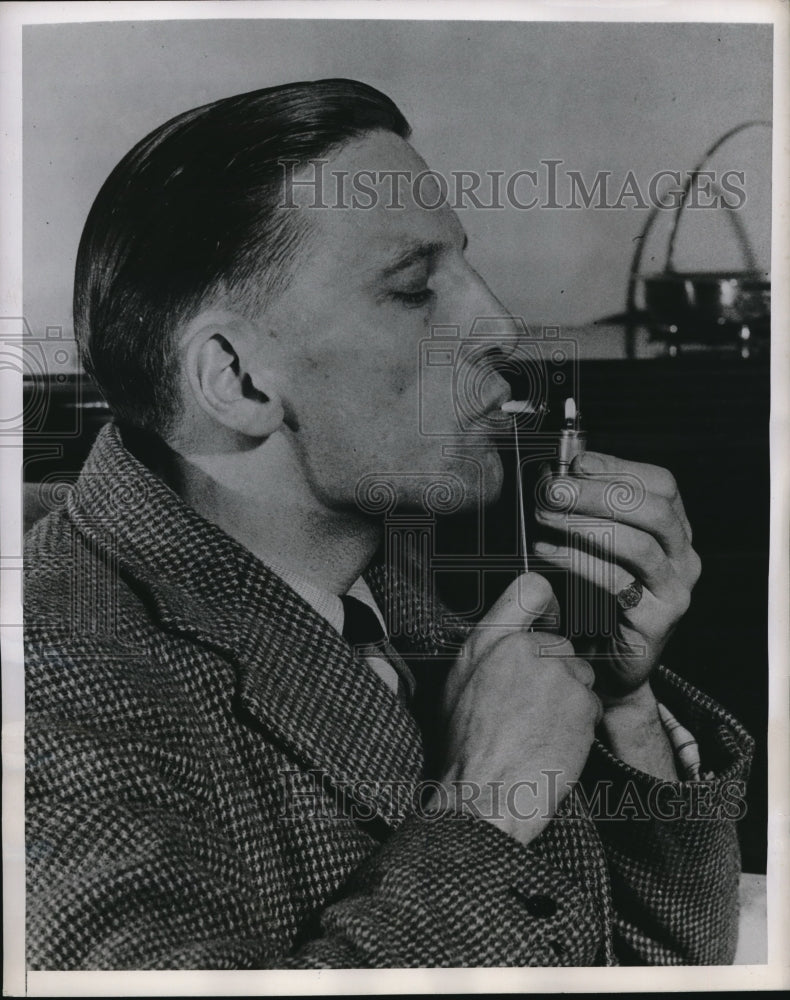 Load image into Gallery viewer, 1948 Press Photo James Spencer smokes a cigarette all the way down due to the
