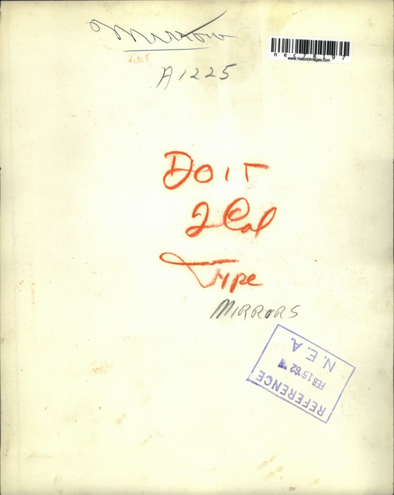 1962 Press Photo A woman cleaning a mirror at her home