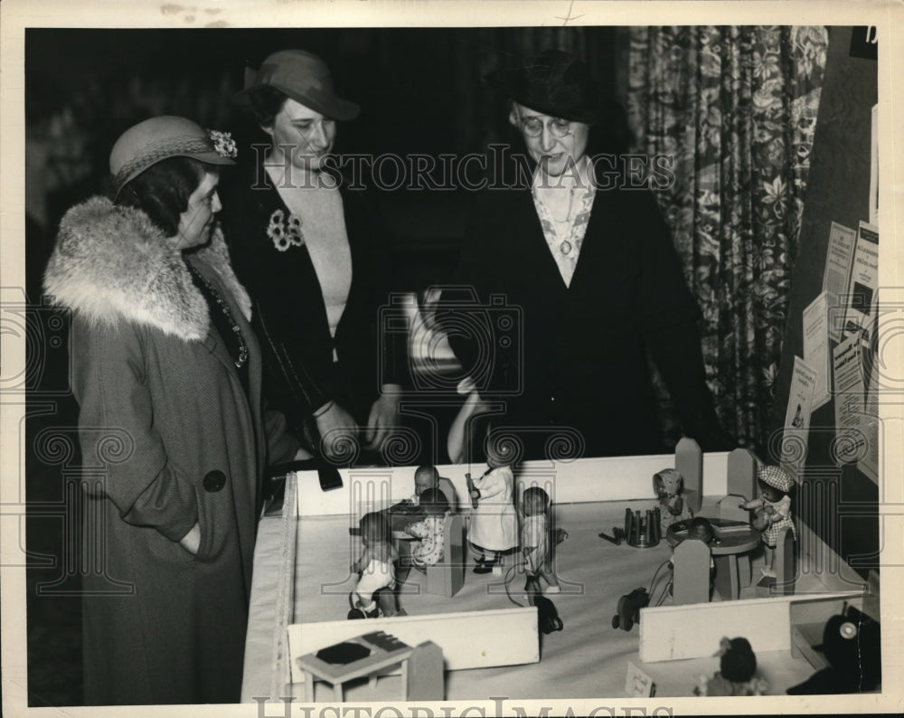 1933 Press Photo Mrs. H Van Y Caldwell, Miss Sophia J Arc looks at play dolls