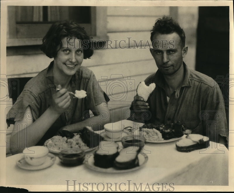 Load image into Gallery viewer, 1924 Press Photo Mr and Mrs Early Oberg eating a meal after a week in the woods
