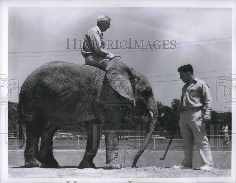 1957 Press Photo Robert Odell, keeper gets to ride on "Flippy" the elephant