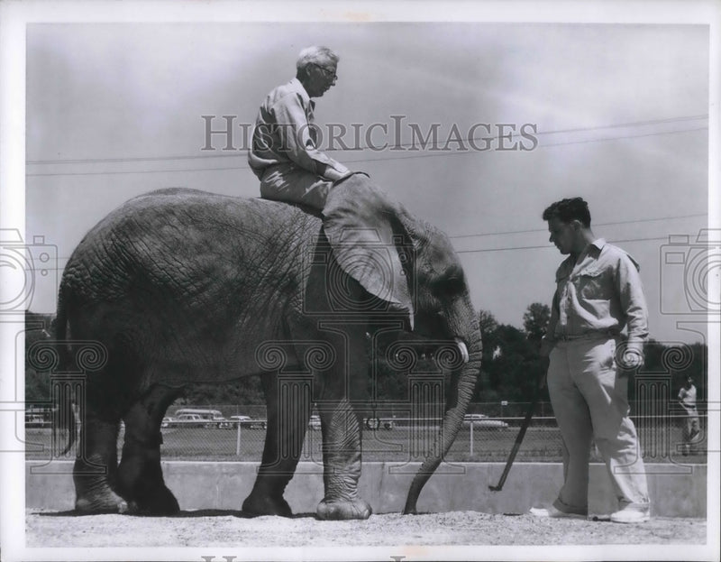 Load image into Gallery viewer, 1957 Press Photo Robert Odell, keeper gets to ride on "Flippy" the elephant
