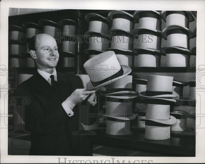 Load image into Gallery viewer, 1939 Press Photo A man holding England Toppers for men in a shop
