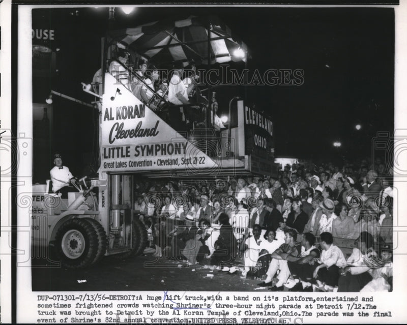 Load image into Gallery viewer, 1956 Press Photo A lift truck in Detroit parading down the street with a band
